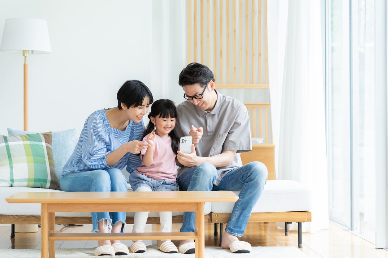 スマホで畑だよりを見る家族(イメージ写真)